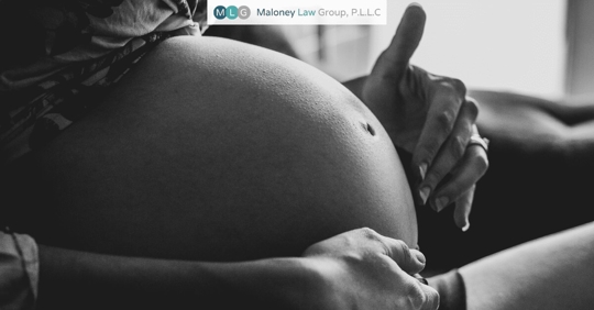 black and white photo of a pregnant belly